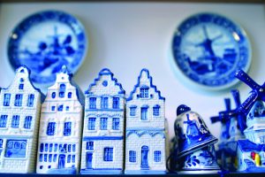 White and blue painted miniature houses, windmills, bells and plates