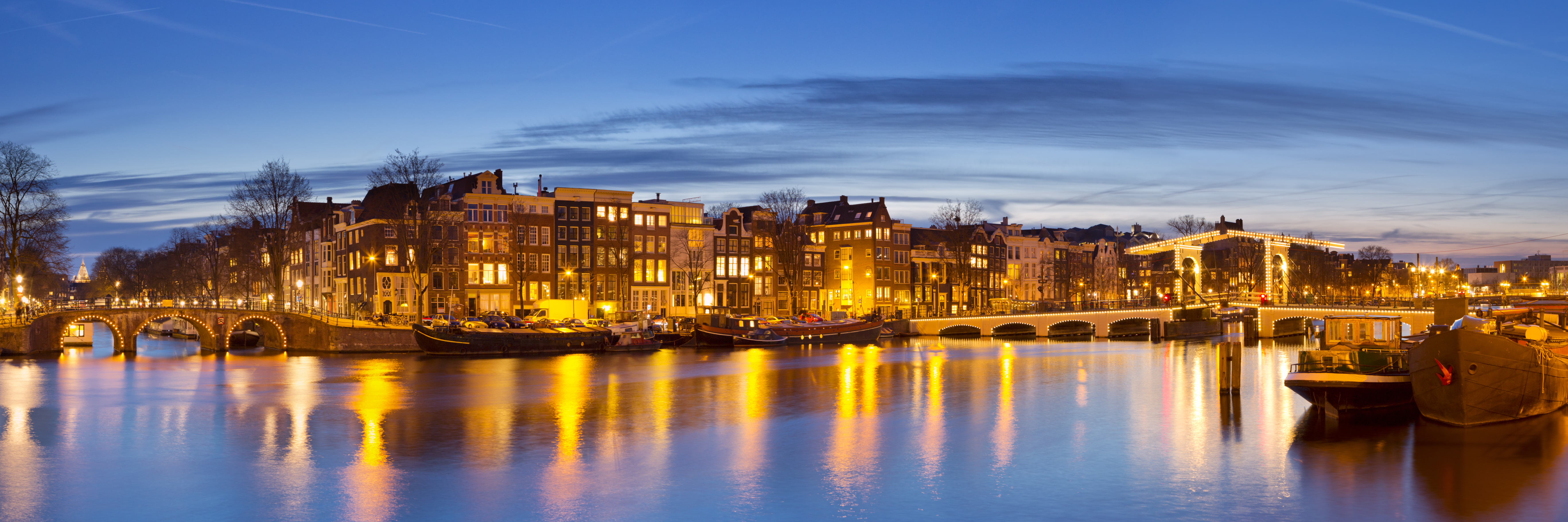 The skinny bridge and typical 17th century houses along Amstel river in Amsterdam