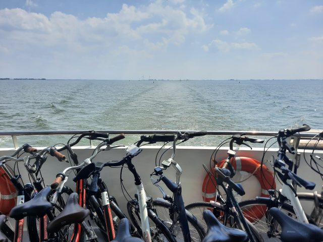 Bicyles parked on a boat, sailing on a big lake