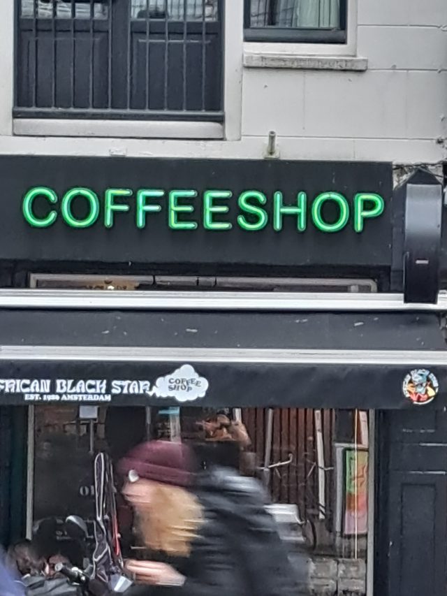 shop sign of a coffeeshop with people in front