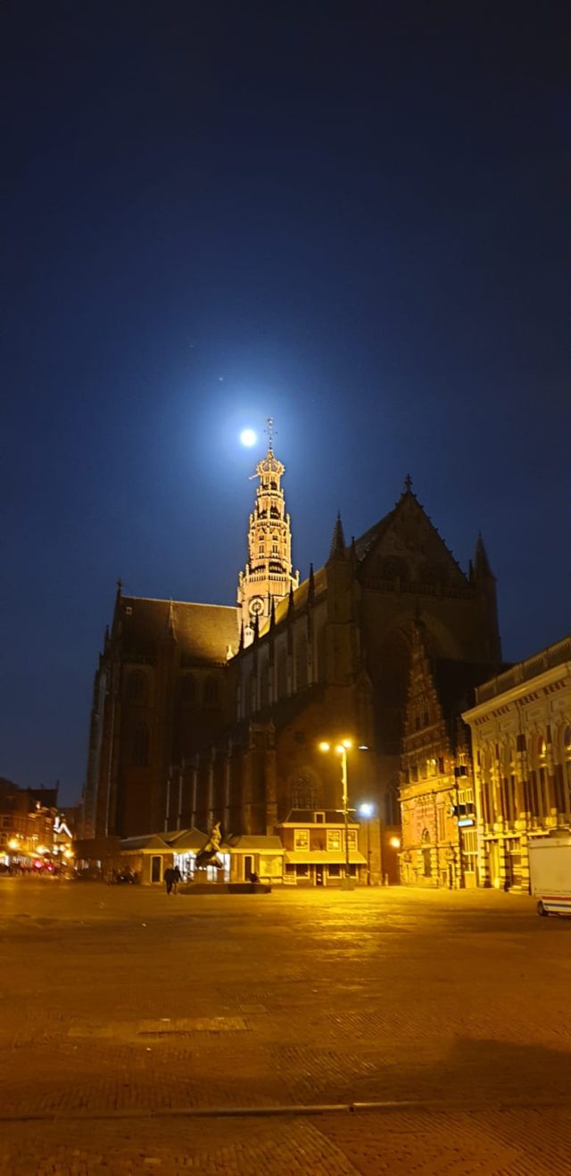 A Gothic church on an empty square in the moonlight