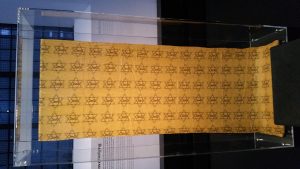 a sheet with yellow Jewish stars in a glass box