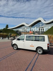 A white minibus parked in front of Madurodam entrance