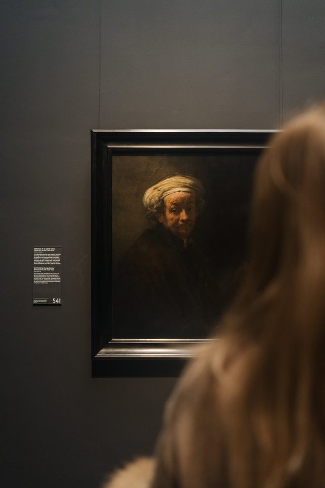 Person looking at a portrait of Rembrandt