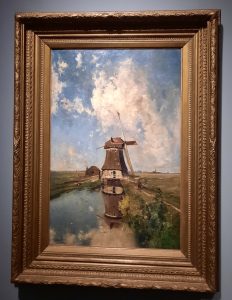 a painting of a windmill with its reflection in the water, under a half clouded sky