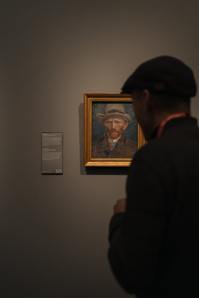 A person looking at a portrait painting of Vincent van Gogh
