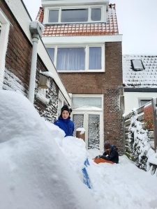 Children playing in the snow in the garden of a town house