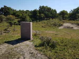 WW2 Monument in the dunes surrounded by trees and vegetation