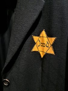 A yellow Jewish star in a black jacket