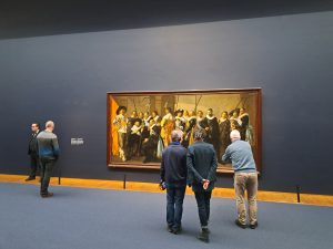 a few people looking at a group painting by Frans Hals